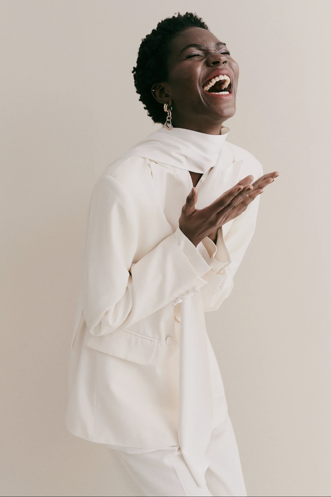 woman wearing white suit laughing